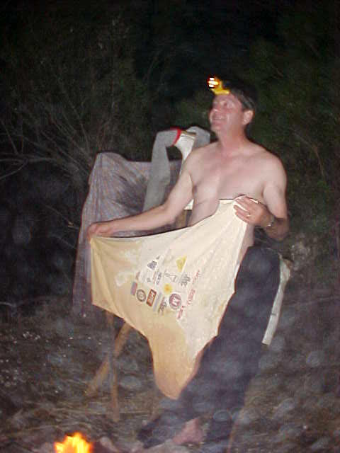 Joe drying out his clothes while doing a gris-gris dance around the fire.
