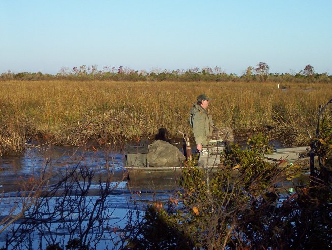 Joe trudging the mud boat through the pond after retrieving the ducks.